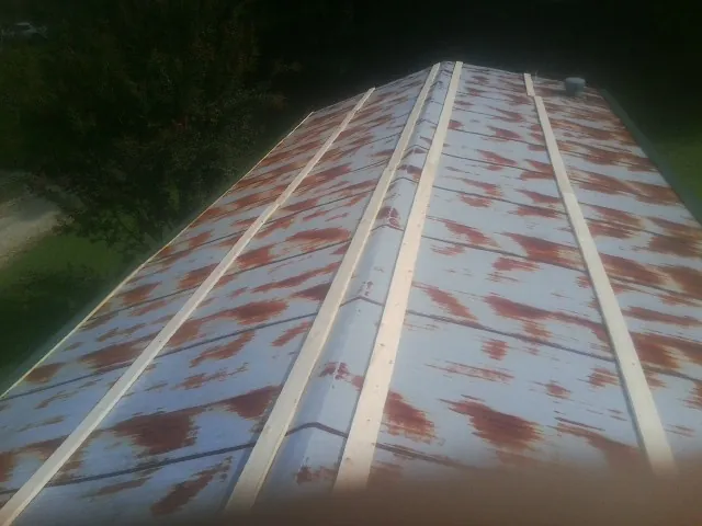 Rusted metal roof panels with new wood purlins before replacement — Storm Damage Roof Repair in Gordonville by Roofing Brothers