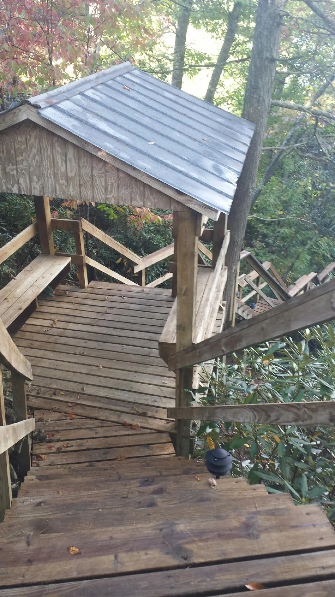 Metal roofed shelter over wooden steps on a wooded walkway — Skylight Repair & Installation work by our crew in Gordonville
