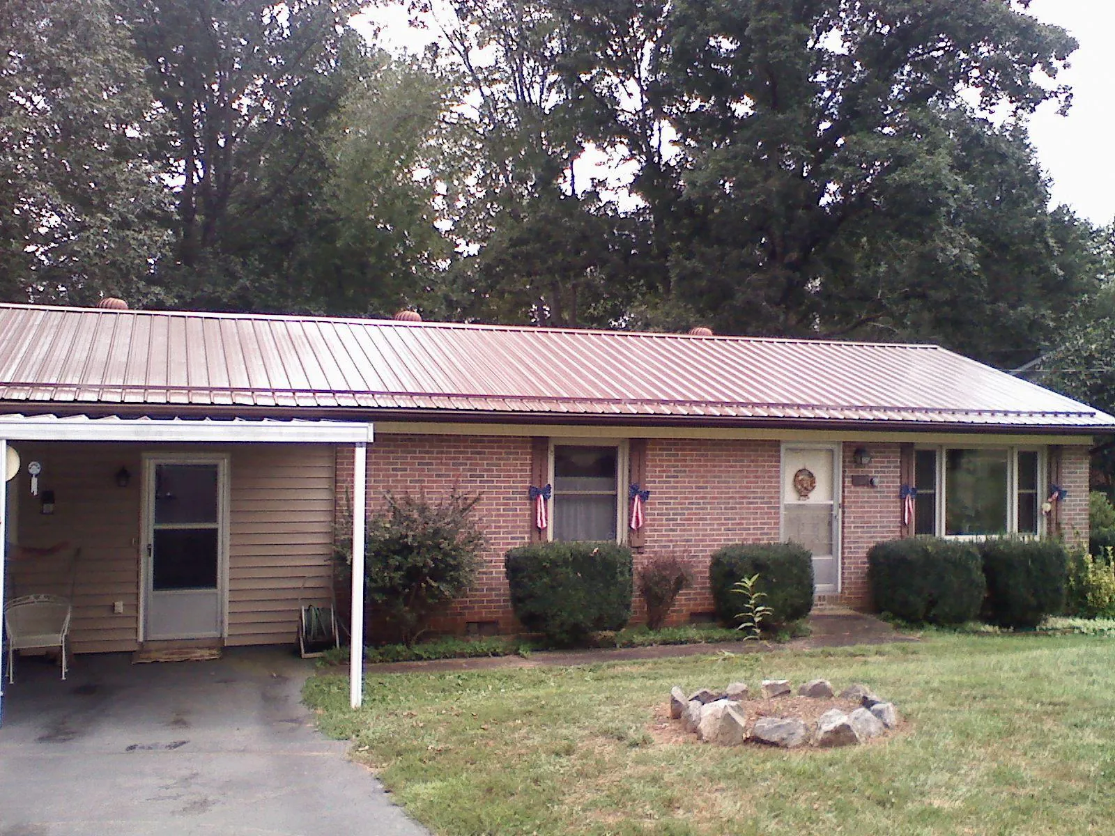 Bronze metal roof and carport on a brick ranch home — Roof Repair work by our crew in Gordonville